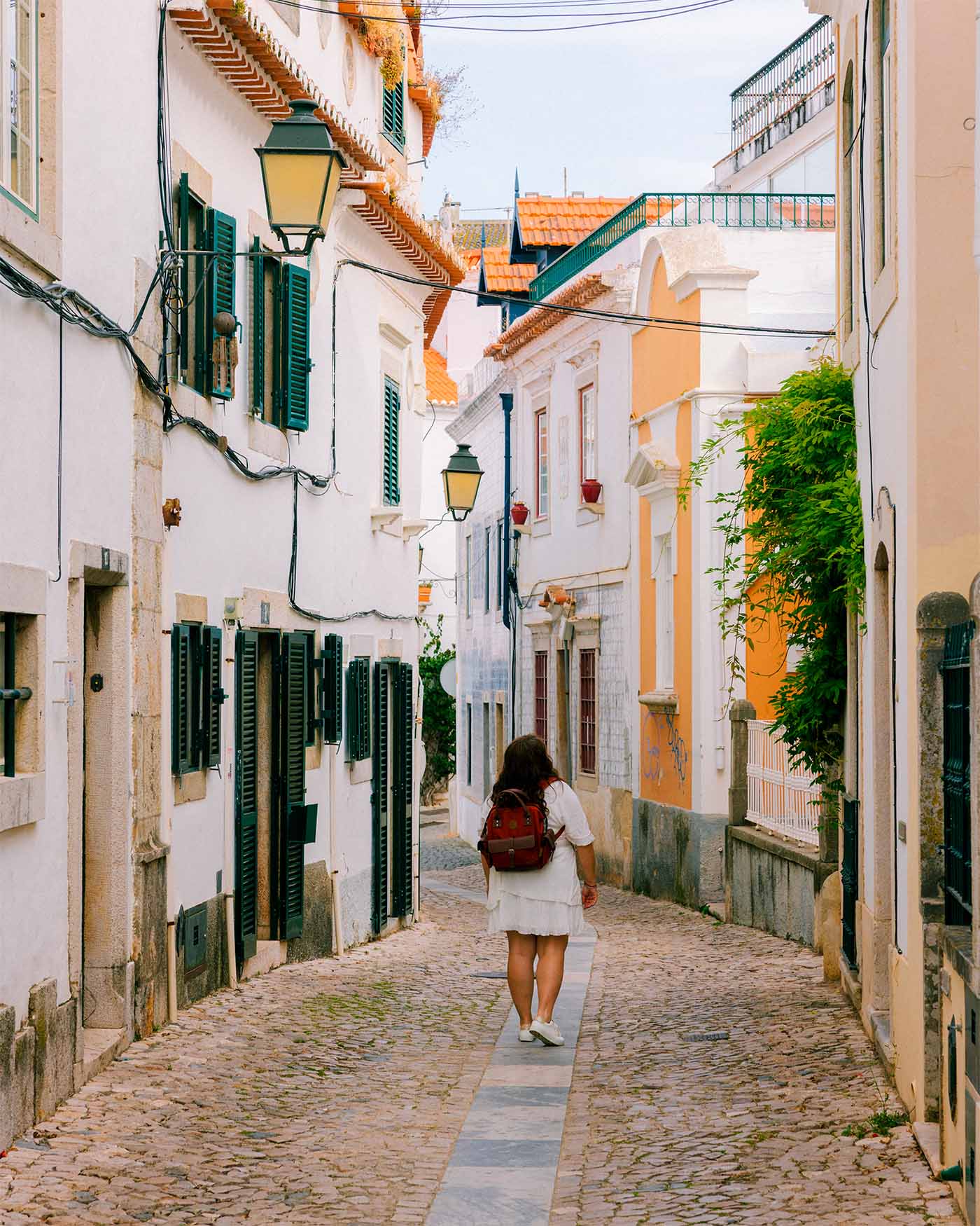 Anne-Sophie se promène au milieu d'une ruelle à Cascais
