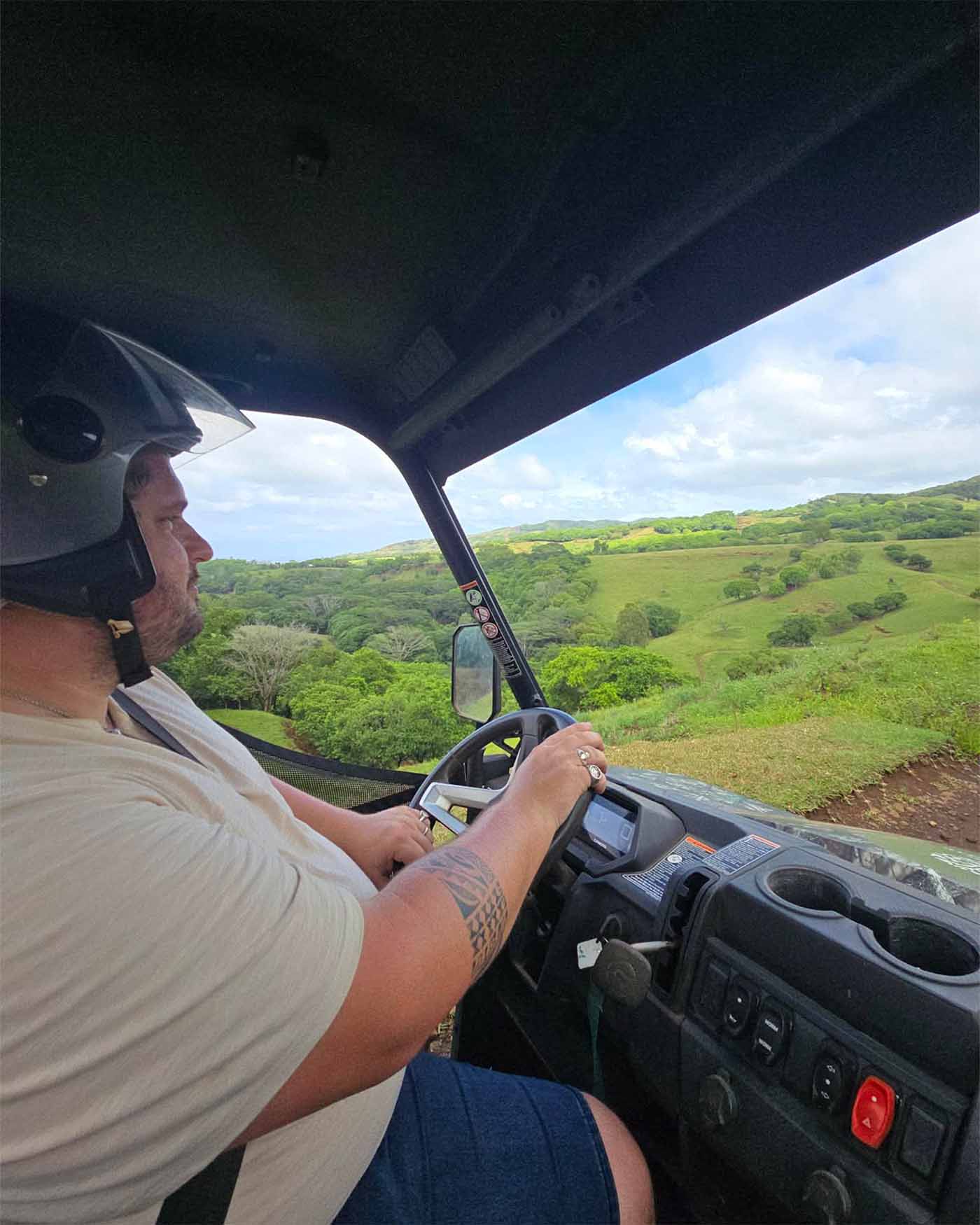 Guillaume conduit le buggy sur un chemin de terre. Il porte un casque noir