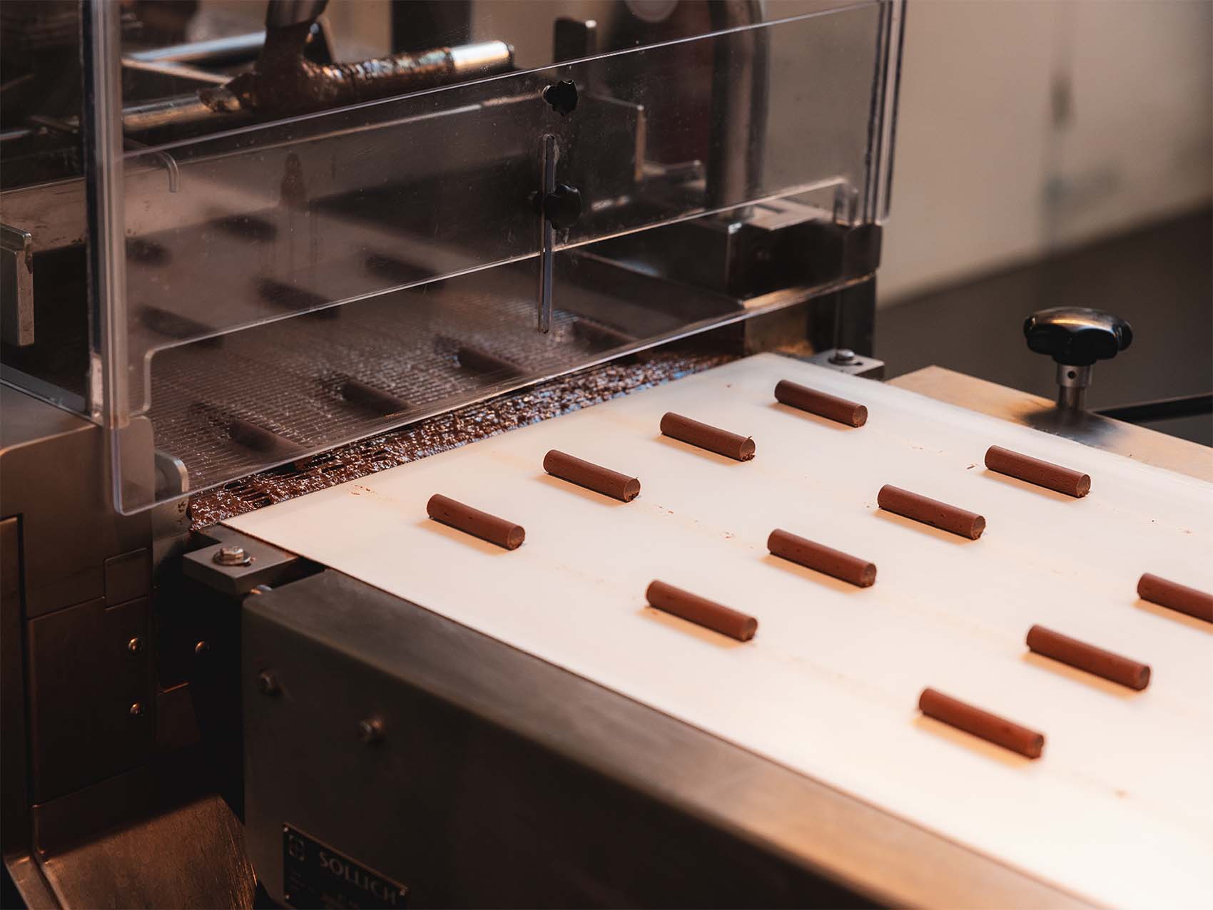 Photo de la fabrication des branches cailler qui sortent sur un tapis roulant