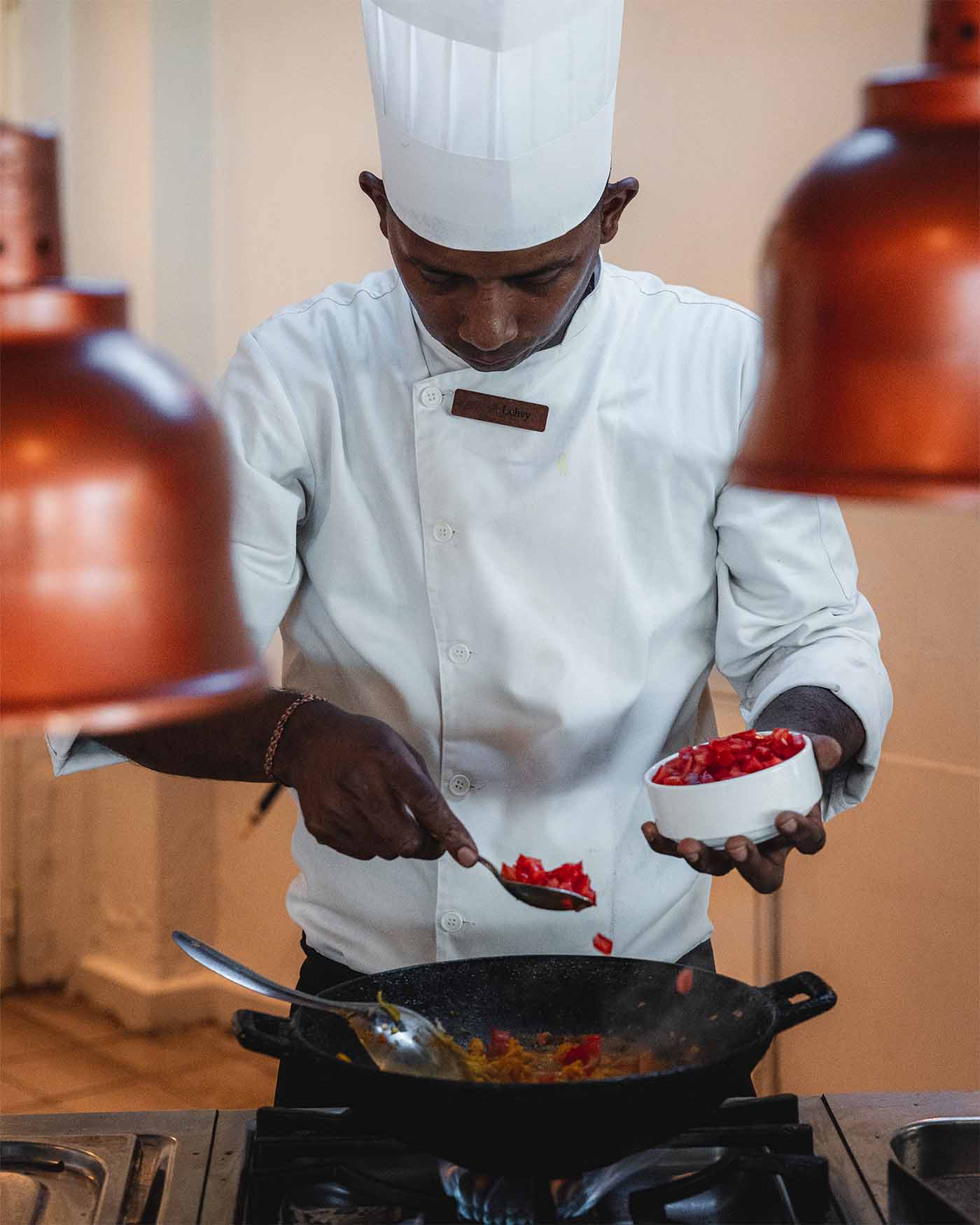 Cour de cuisine : cari poulet. Le chef assaisonne le plat