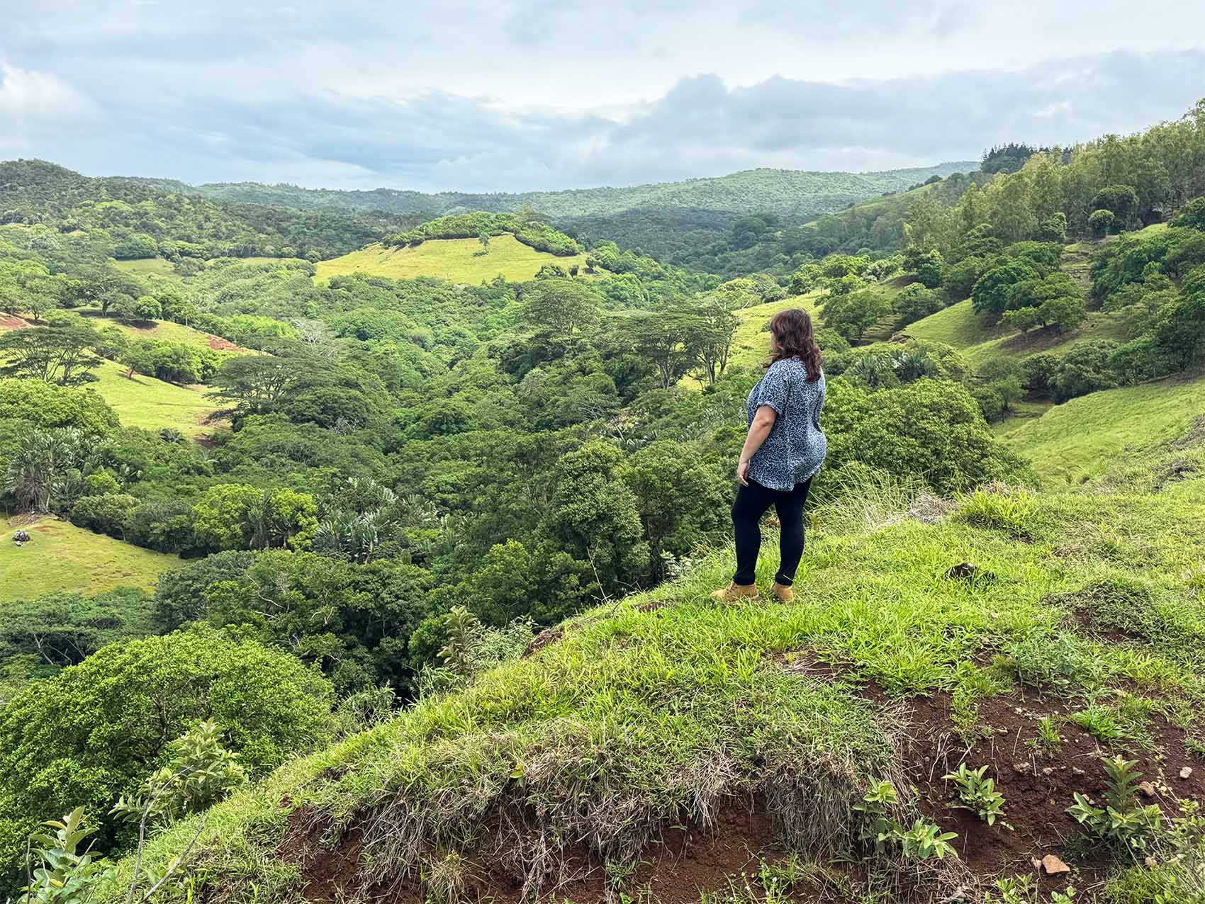 Anne-Sophie face au domaine de bel ombre. Grand paysage vert à perte de vue